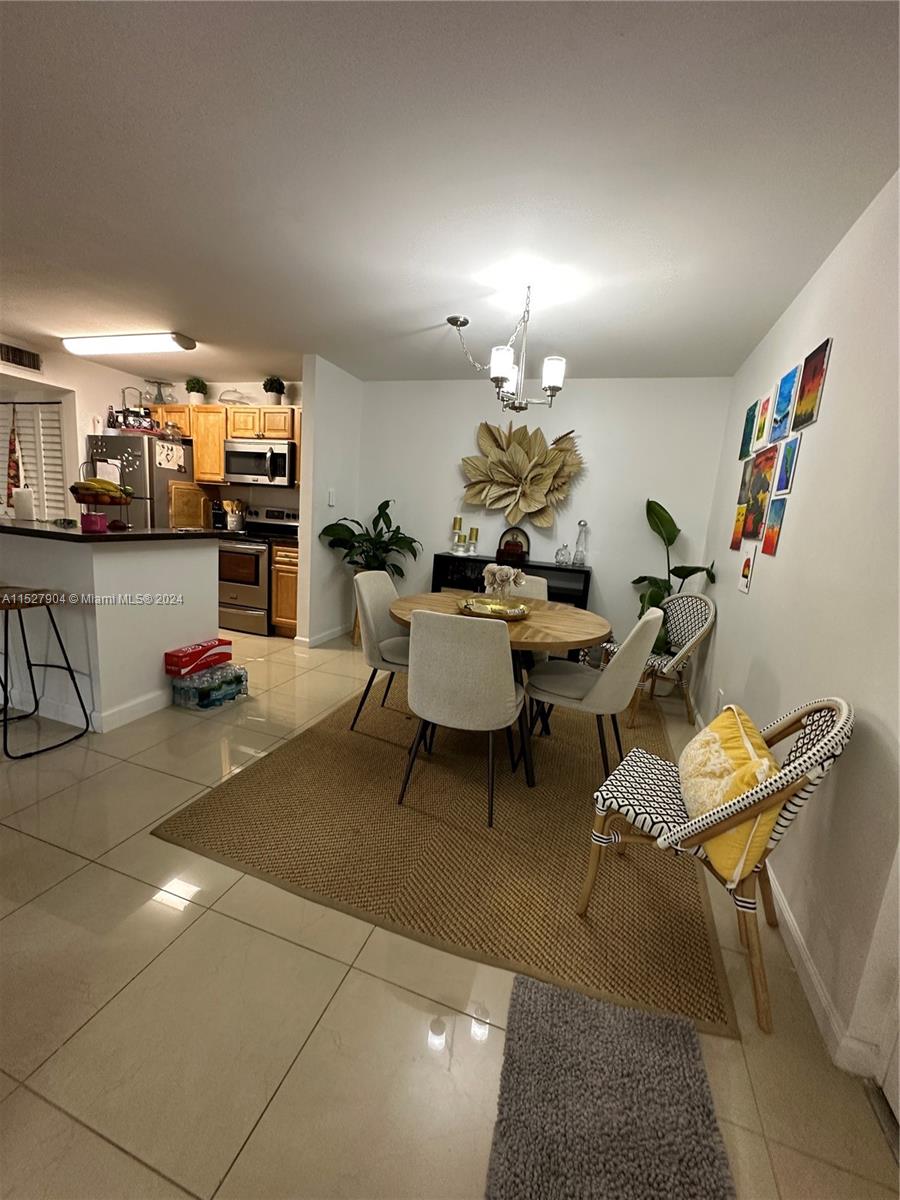 15821 Southwest 104th Terrace, Unit 203 Miami, FL 33196 - Photo 3 of 25 a living room with furniture and a dining table with wooden floor