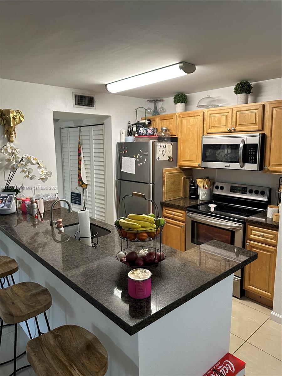 15821 Southwest 104th Terrace, Unit 203 Miami, FL 33196 - Photo 9 of 25 a kitchen with stainless steel appliances granite countertop a stove and a sink