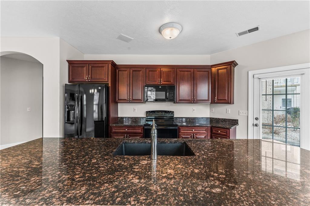 216 Adams Pointe Boulevard, Unit 10 Mars, PA 16046 - Photo 12 of 33 a kitchen with kitchen island granite countertop a refrigerator and a stove top oven