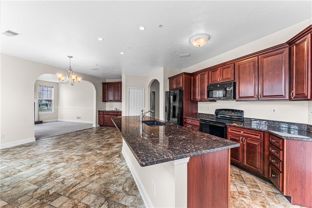 216 Adams Pointe Boulevard, Unit 10 Mars, PA 16046 - Photo 13 of 33 a kitchen with kitchen island granite countertop a stove top oven a sink dishwasher a dining table and chairs with wooden floor