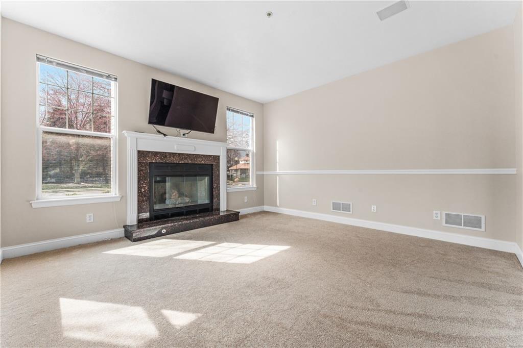 216 Adams Pointe Boulevard, Unit 10 Mars, PA 16046 - Photo 16 of 33 a living room with a fireplace and a flat screen tv
