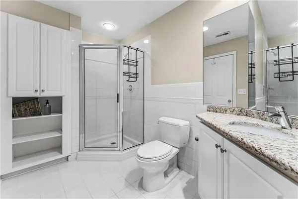 a bathroom with a granite countertop sink a toilet and shower
