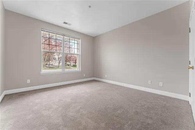 an empty room with windows and closet