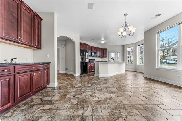 a view of a kitchen with stainless steel appliances granite countertop a refrigerator and cabinets