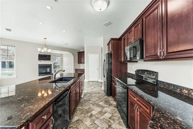 a kitchen with granite countertop a stove and a sink