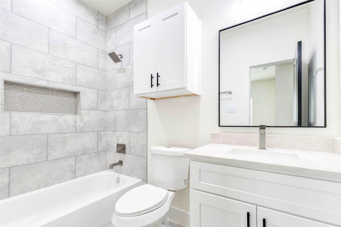 7115 England Street, Unit B Houston, TX 77021 - Photo 13 of 19 This secondary bathroom offers a shower-tub combo with large-format tile surrounds and a crisp white vanity.