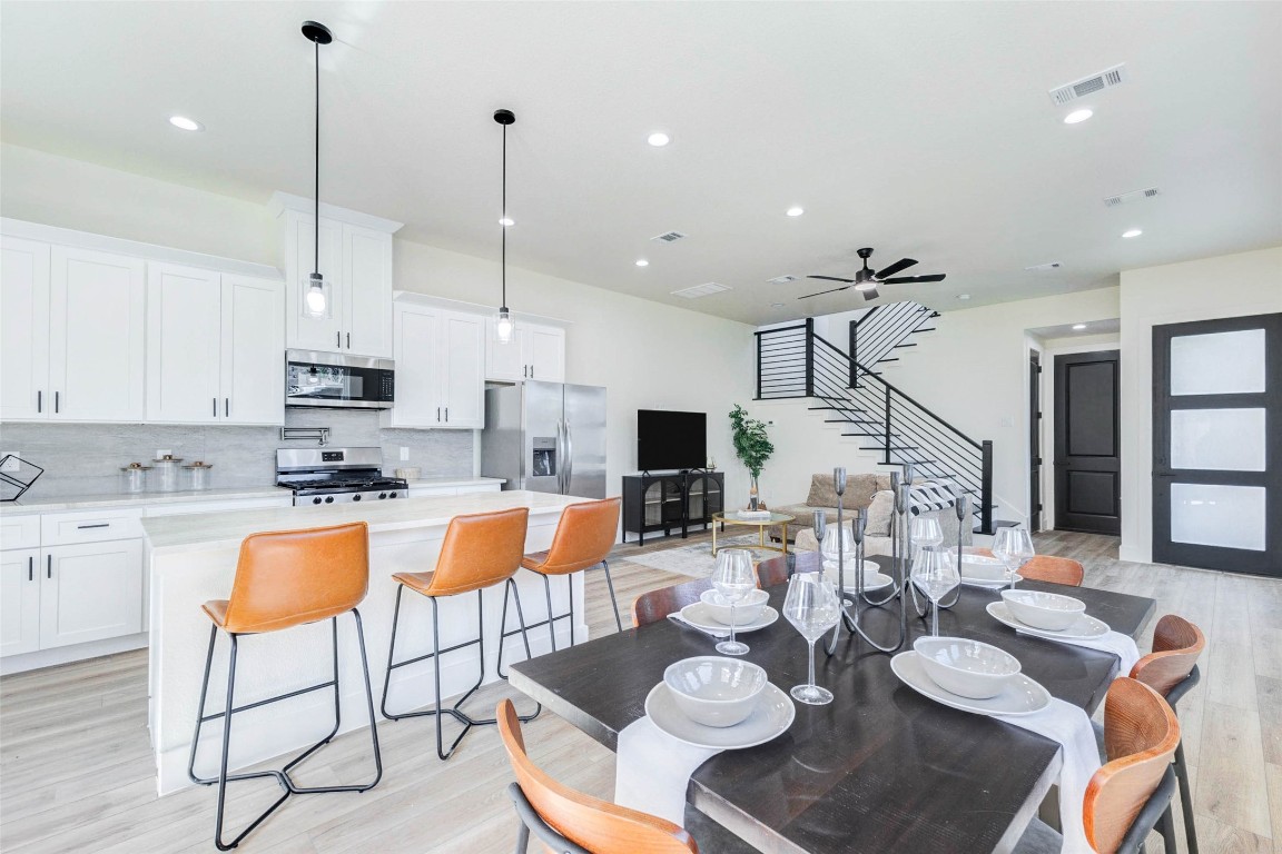 7115 England Street, Unit B Houston, TX 77021 - Photo 2 of 19 A chef-inspired kitchen boasts white Shaker-style cabinetry, light stone countertops, and a full suite of stainless steel appliances.