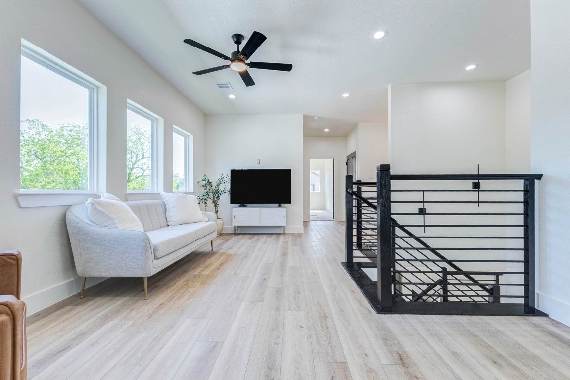 7115 England Street, Unit B Houston, TX 77021 - Photo 6 of 19 Recessed LED lighting and a contemporary ceiling fan complement the airy feel of the upper-floor gallery. Four oversized picture windows line the wall, flooding the second-story flex space with natural light.