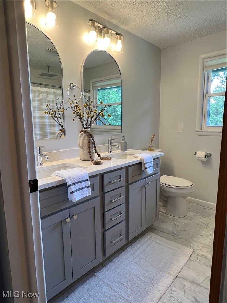 232 Hoffman Road Loudonville, OH 44842 - Photo 4 of 28 Full bath featuring a textured ceiling, marble finish floors, double vanity, and plenty of natural light