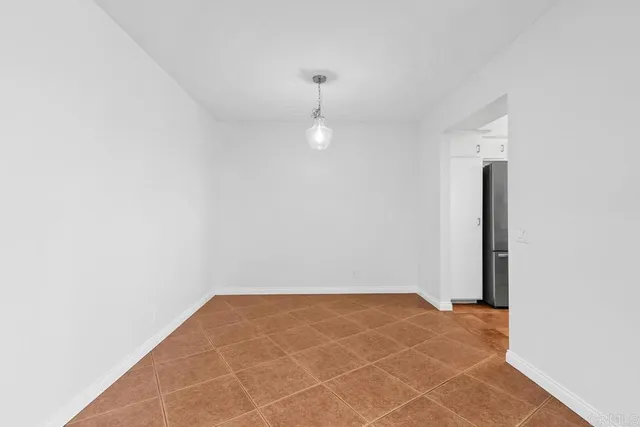 an empty room with a ceiling fan and carpet