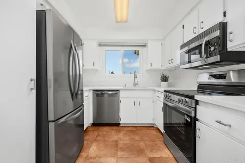 a kitchen with stainless steel appliances granite countertop a refrigerator sink and stove