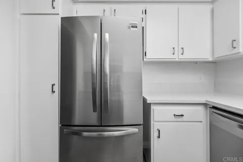 a close view of a refrigerator in kitchen and cabinets