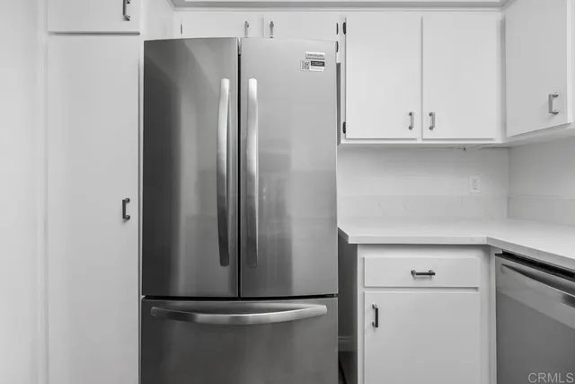 a close view of a refrigerator in kitchen and cabinets