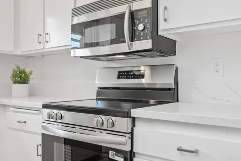 a stove top oven sitting inside of a kitchen