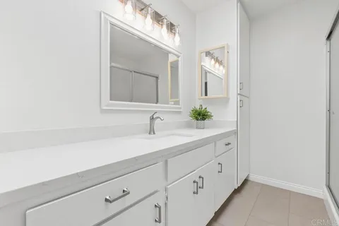 a spacious bathroom with a double vanity sink toilet and a mirror