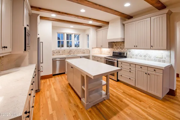a kitchen with a stove sink and cabinets