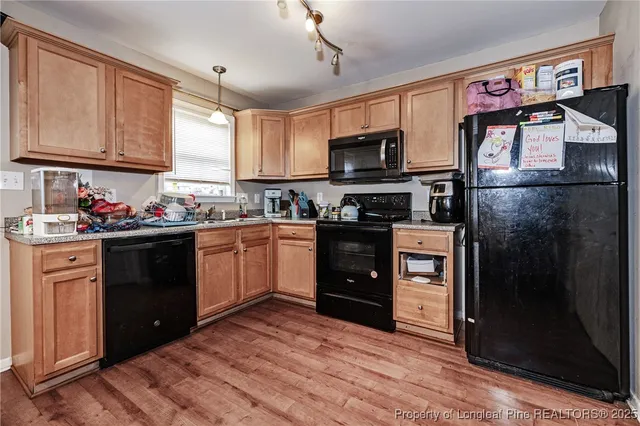 a kitchen with stainless steel appliances granite countertop a refrigerator stove and sink