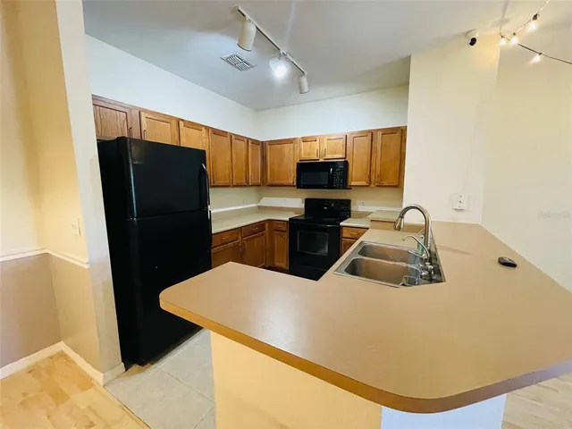 a kitchen with stainless steel appliances granite countertop a refrigerator and a sink