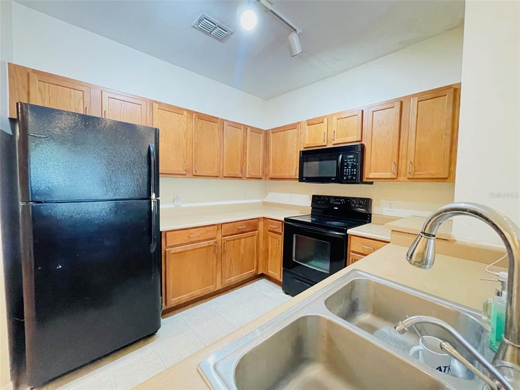 8201 Claire Ann Drive, Unit 202 Orlando, FL 32825 - Photo 9 of 17 a kitchen with stainless steel appliances granite countertop a refrigerator and a sink