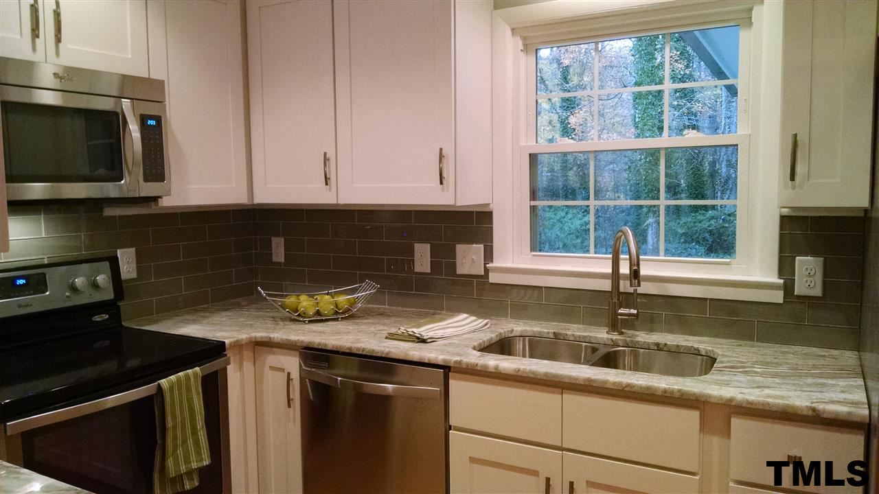 1224 Kingston Ridge Road Cary, NC 27511 - Photo 4 of 24 Quartz counters and white shaker cabinets with soft closers on doors and drawers.