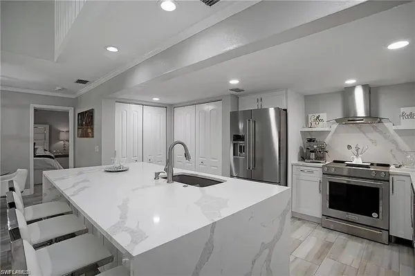 a kitchen with stainless steel appliances granite countertop a stove refrigerator and a sink