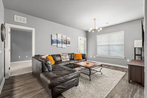 a living room with furniture and a chandelier