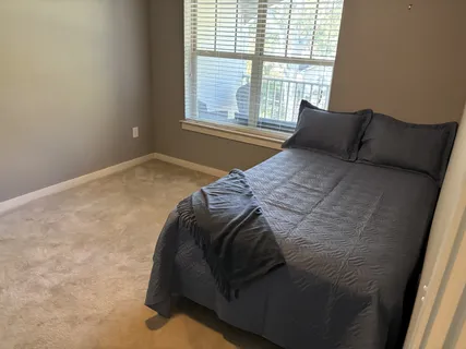 a bed sitting in a bedroom next to a window