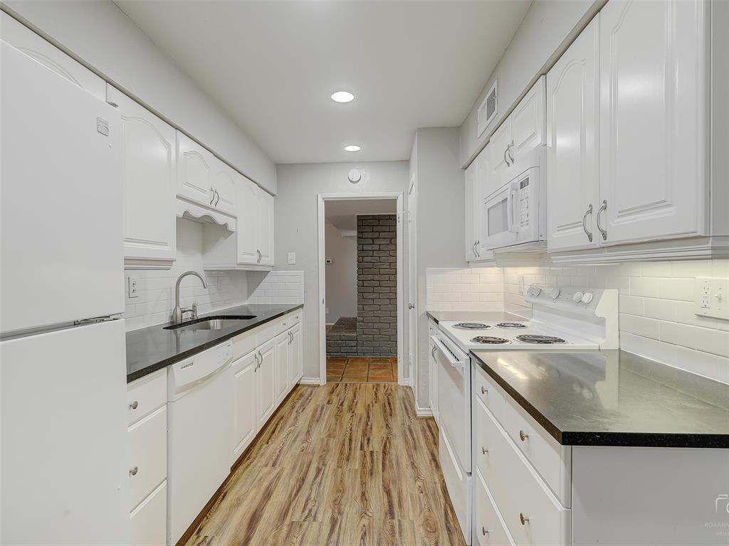 4079 Calculus Drive Dallas, TX 75244 - Photo 10 of 26 a kitchen with granite countertop white cabinets and white appliances