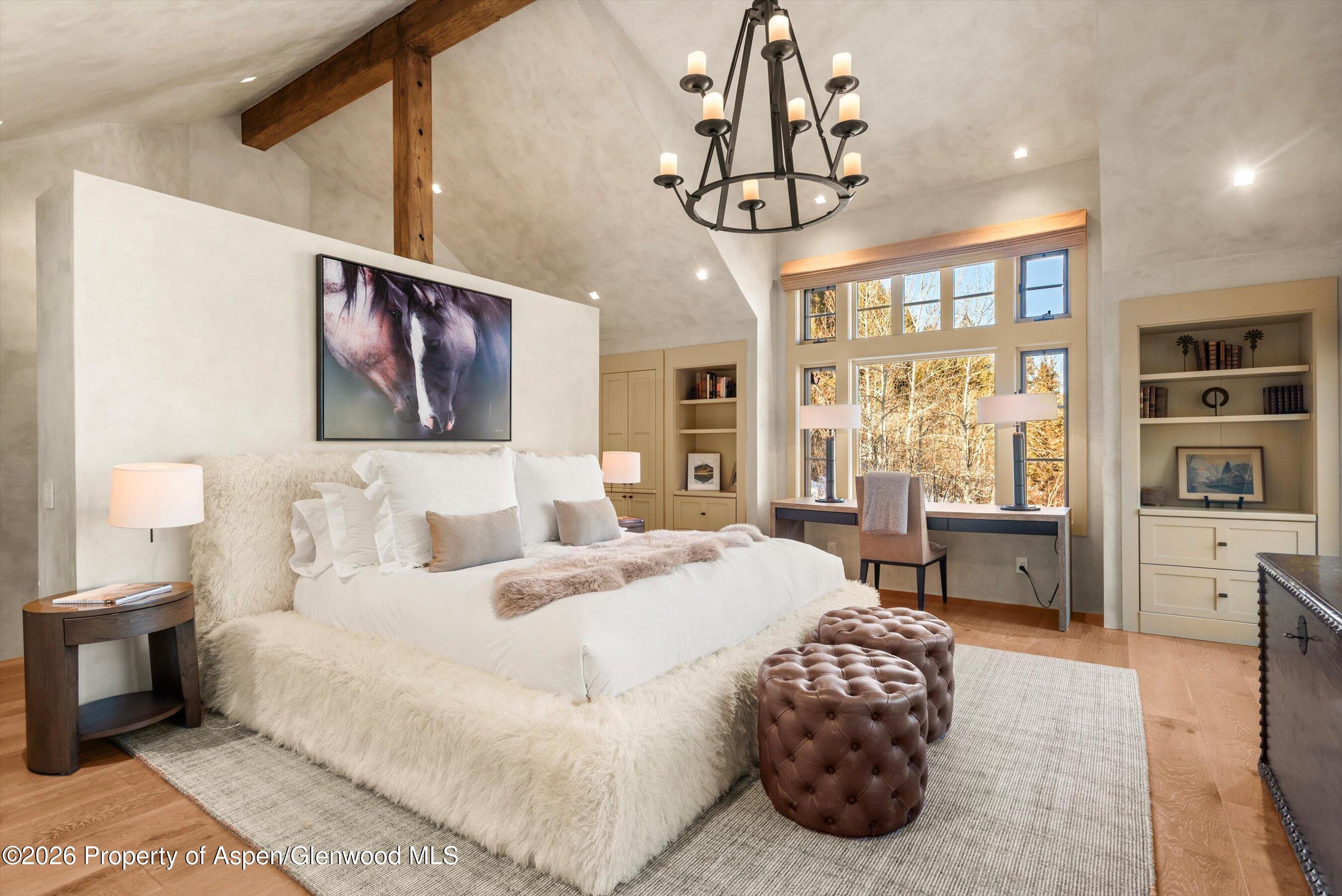 1271 Ute Avenue Aspen, CO 81611 - Photo 11 of 53 a bedroom with a large bed chandelier and a window