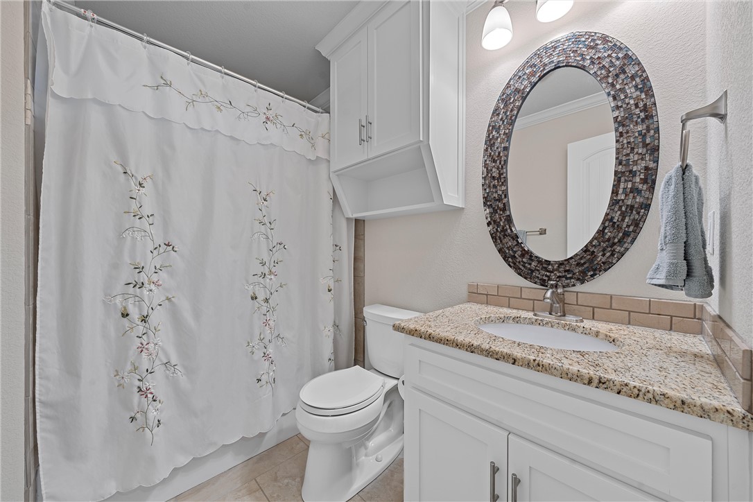 1929 Trinity Drive Waco, TX 76710 - Photo 15 of 22 a bathroom with a granite countertop sink mirror vanity and toilet
