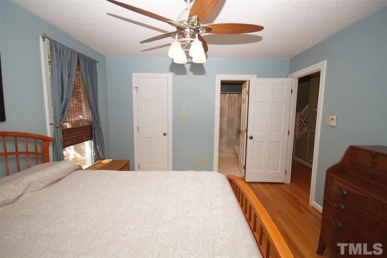 7033 Sandringham Court Raleigh, NC 27613 - Photo 14 of 25 a bedroom with a bed and wooden floor