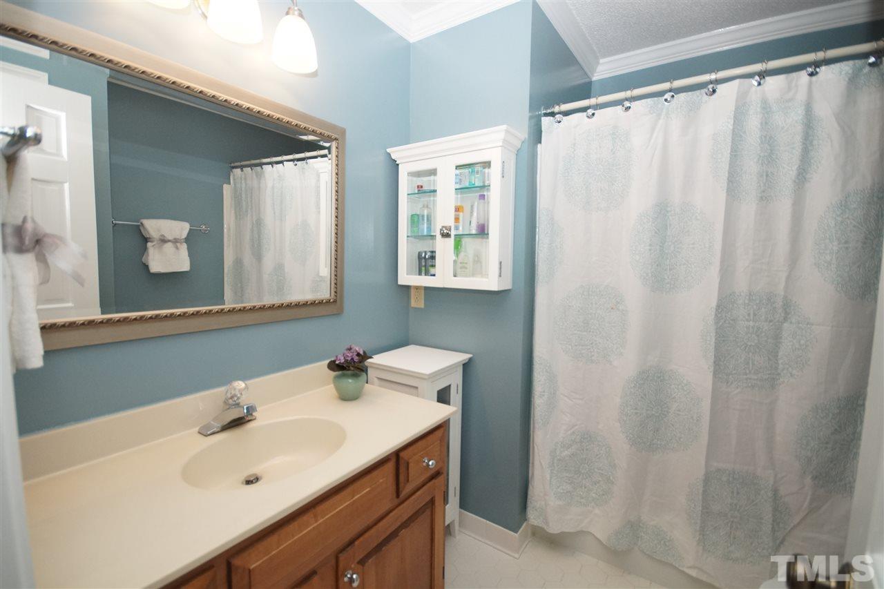 7033 Sandringham Court Raleigh, NC 27613 - Photo 15 of 25 a bathroom with a sink and a mirror