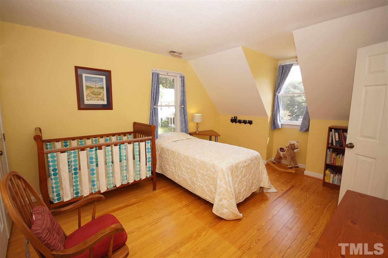 7033 Sandringham Court Raleigh, NC 27613 - Photo 16 of 25 a bedroom with a bed and wooden floor