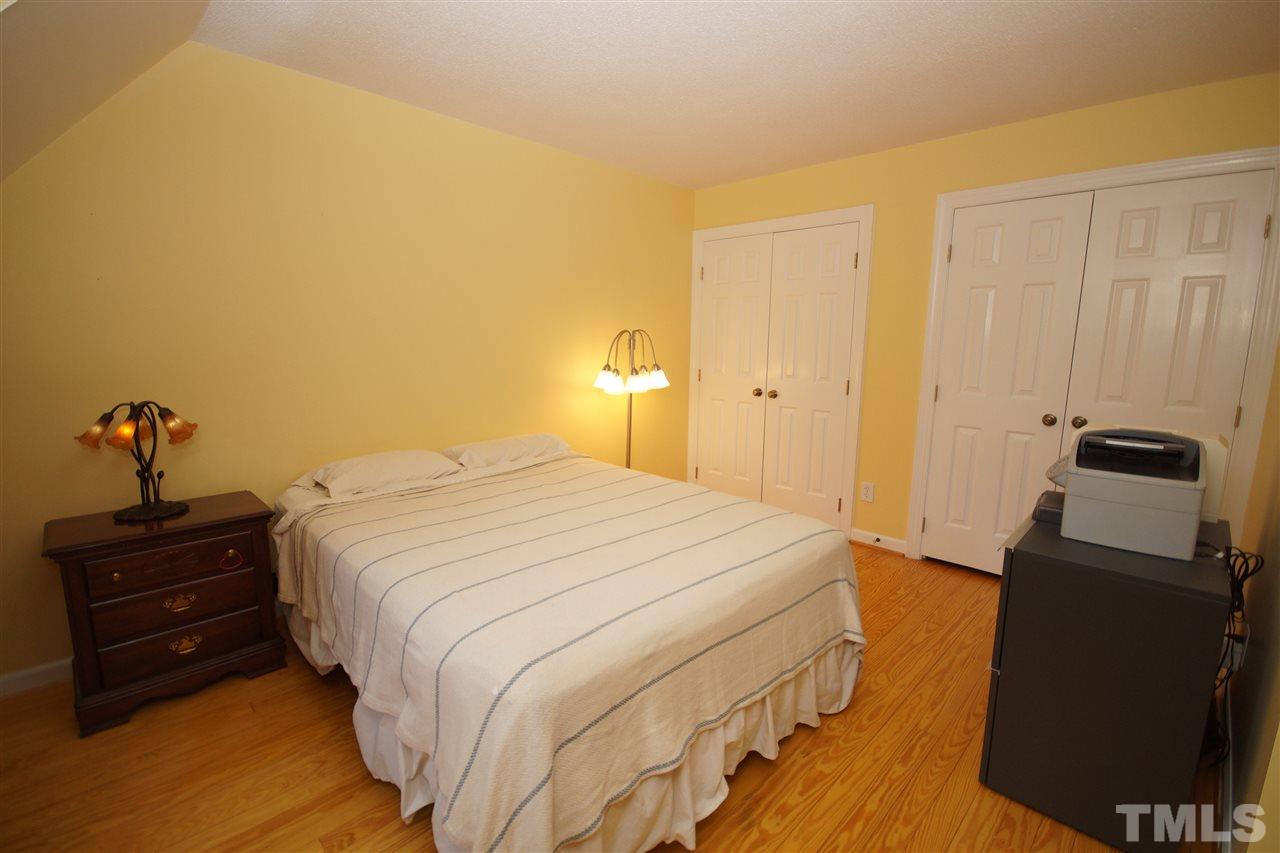 7033 Sandringham Court Raleigh, NC 27613 - Photo 18 of 25 a bedroom with a bed and wooden floor