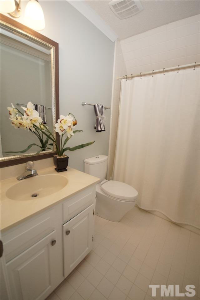 7033 Sandringham Court Raleigh, NC 27613 - Photo 20 of 25 a bathroom with a sink a toilet and shower