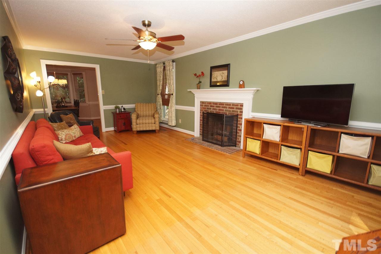 7033 Sandringham Court Raleigh, NC 27613 - Photo 3 of 25 a living room with furniture and a flat screen tv