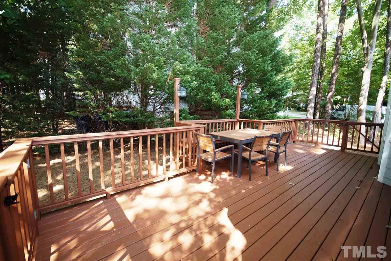 7033 Sandringham Court Raleigh, NC 27613 - Photo 21 of 25 a view of a roof deck with table and chairs and wooden floor