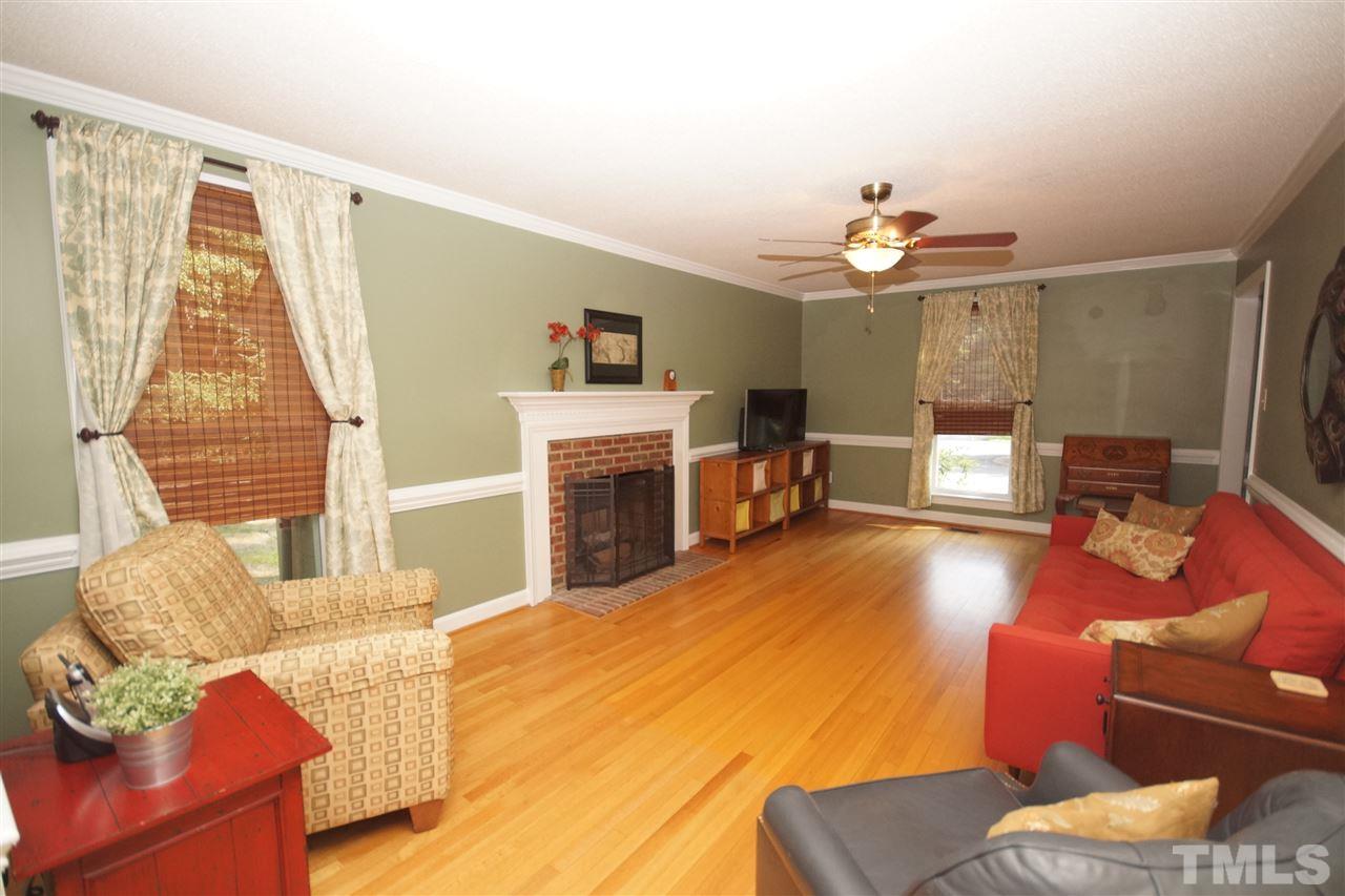 7033 Sandringham Court Raleigh, NC 27613 - Photo 5 of 25 a living room with furniture a fireplace and a flat screen tv