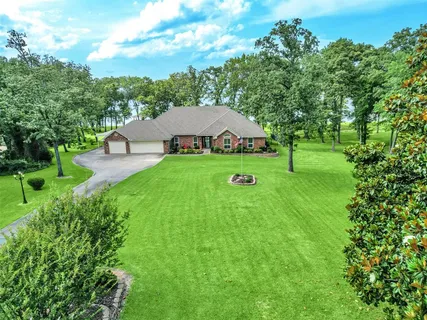a view of an house with a yard and trees