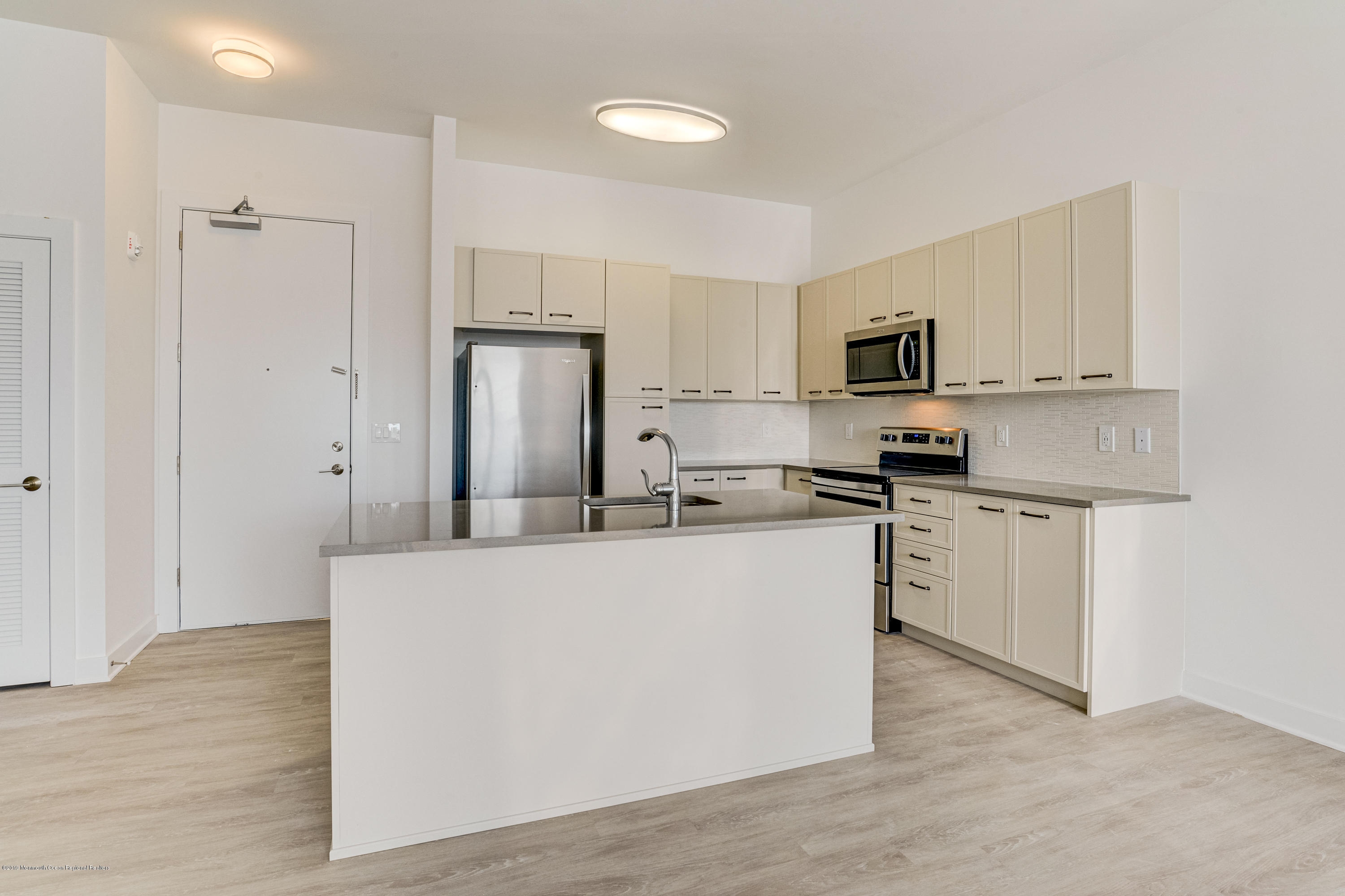 55 West Front Street, Unit 310 Red Bank, NJ 07701 - Photo 4 of 24 a kitchen with white cabinets and stainless steel appliances