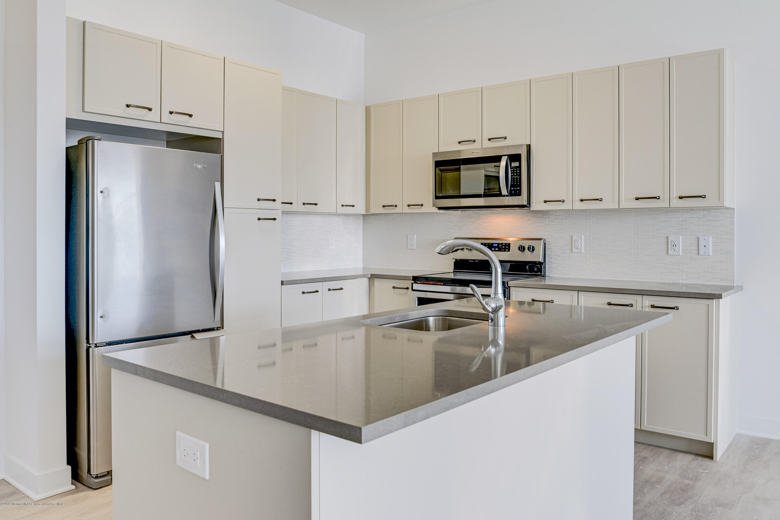 55 West Front Street, Unit 310 Red Bank, NJ 07701 - Photo 5 of 24 a kitchen with stainless steel appliances granite countertop a refrigerator a stove a microwave and a sink