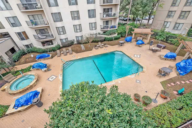 a view of a swimming pool with a lounge chairs in front of a house