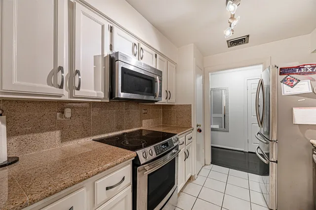 a kitchen with stainless steel appliances granite countertop a sink stove and microwave