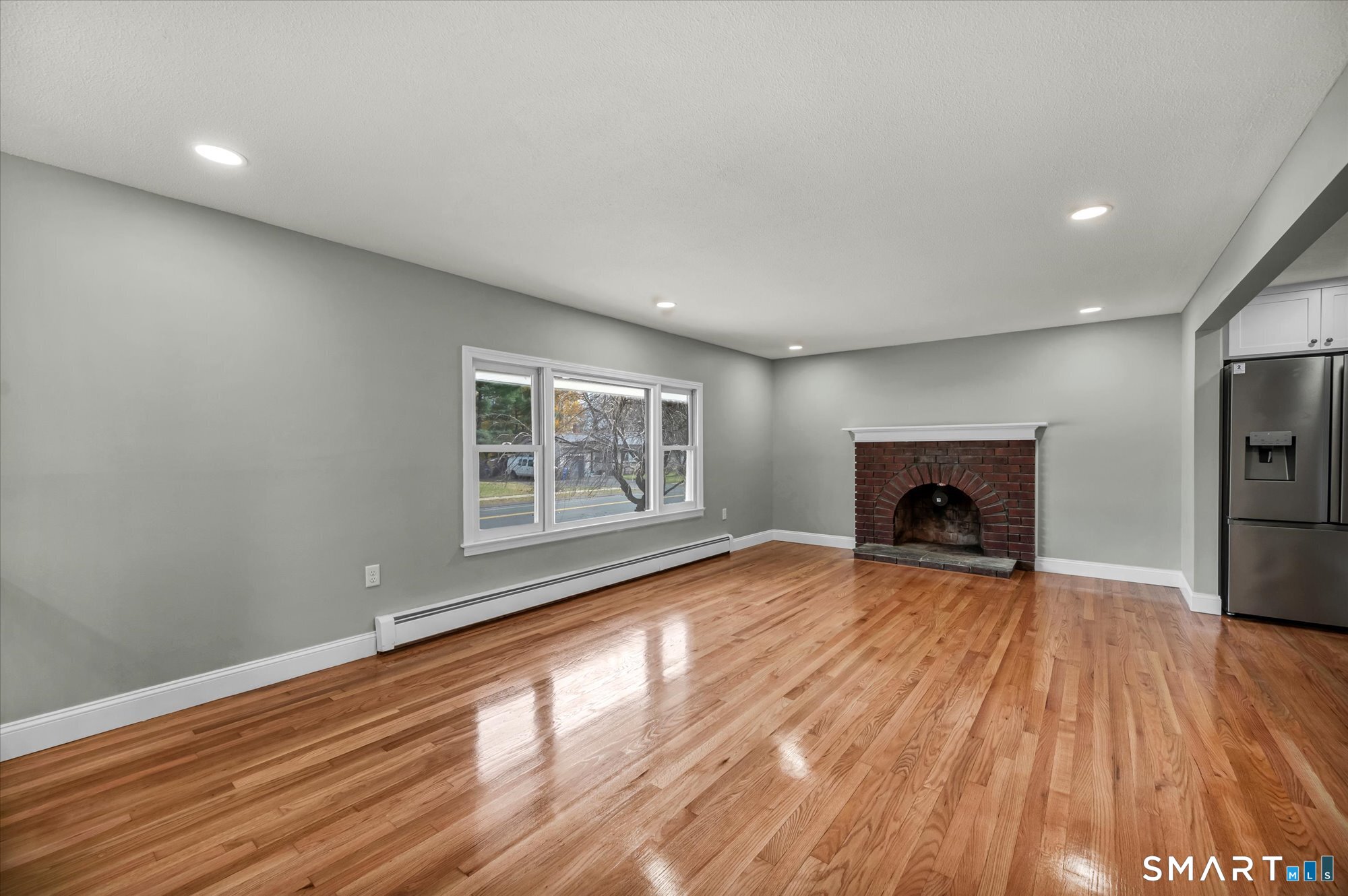 84 Raffia Road Enfield, CT 06082 - Photo 15 of 34 a view of empty room with wooden floor and fireplace