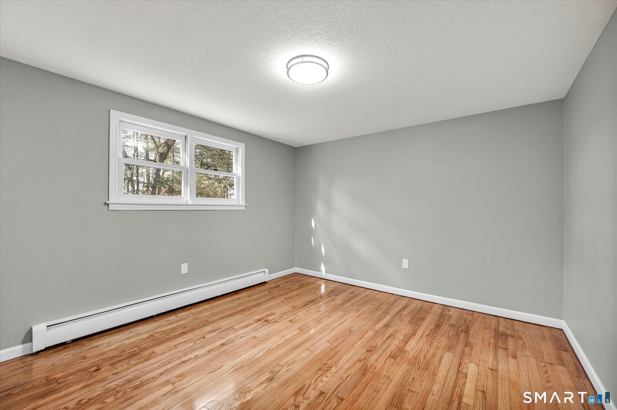 84 Raffia Road Enfield, CT 06082 - Photo 19 of 34 an empty room with wooden floor and windows