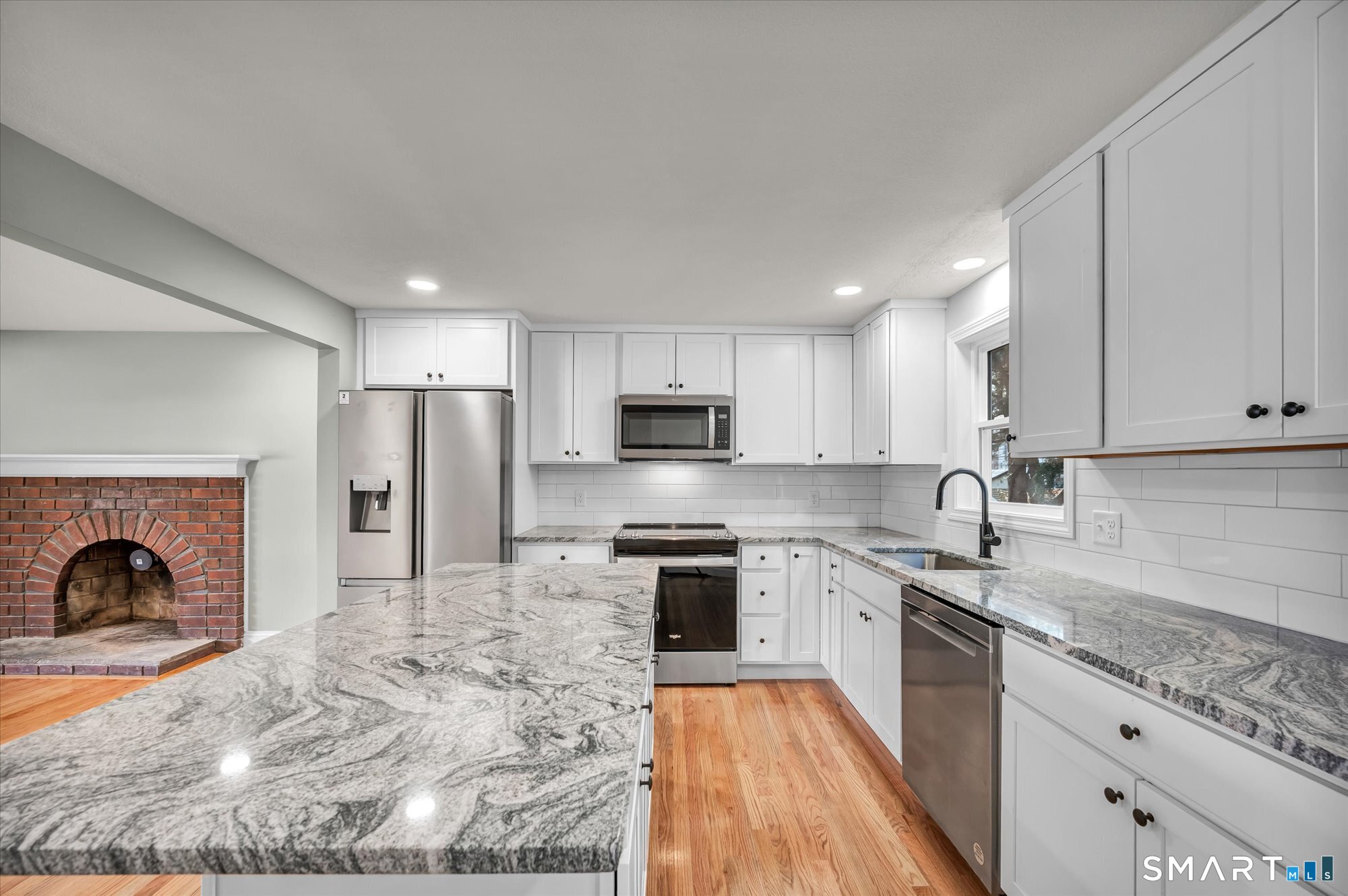 84 Raffia Road Enfield, CT 06082 - Photo 3 of 34 a kitchen with stainless steel appliances granite countertop a stove top oven a sink dishwasher a refrigerator and a oven with wooden floor