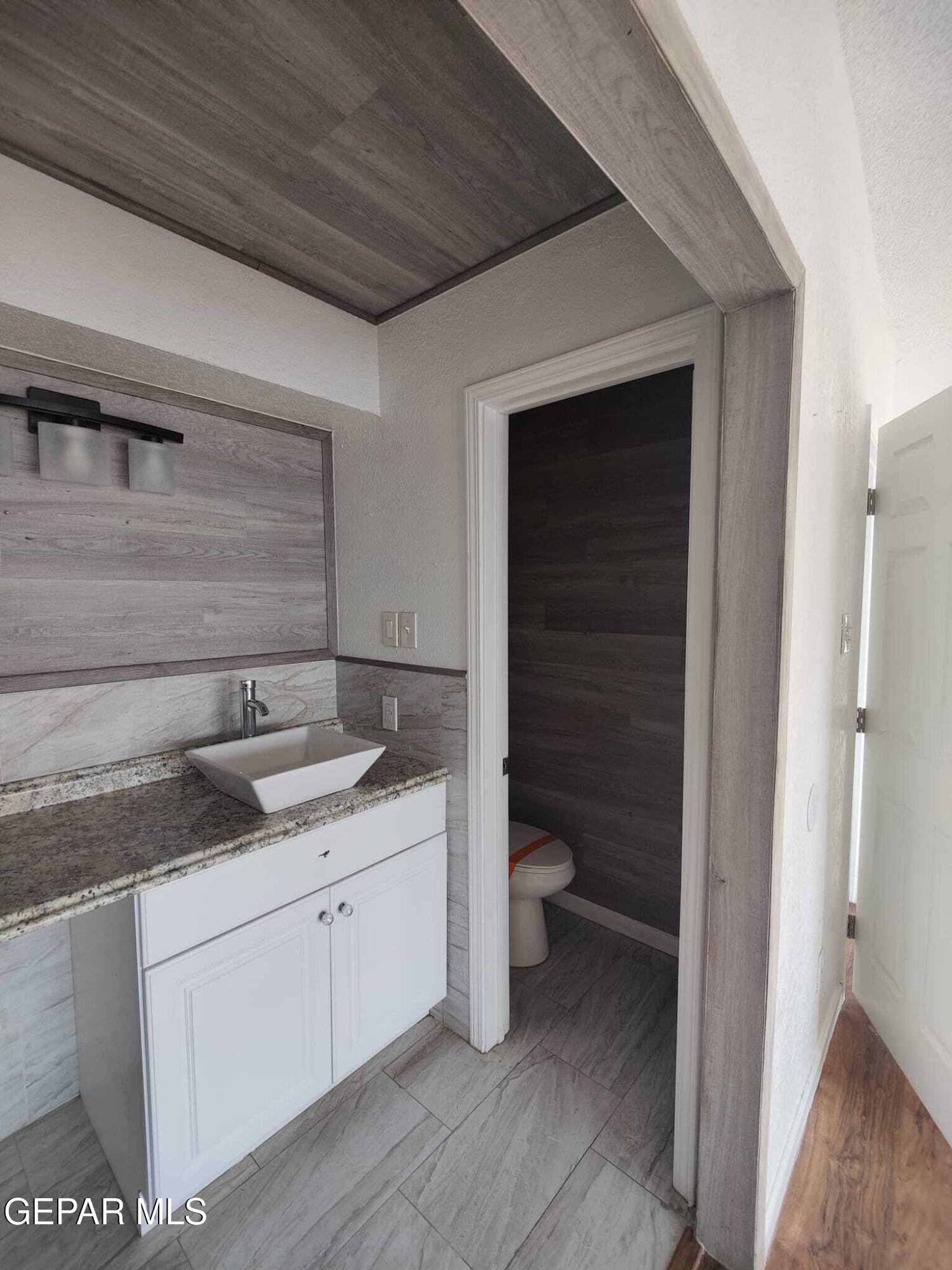 1639 Brian Ray Circle El Paso, TX 79936 - Photo 43 of 52 a bathroom with a granite countertop sink a toilet and a vanity