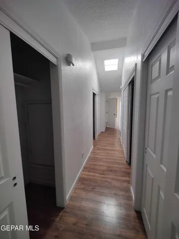 a view of a hallway with wooden floor