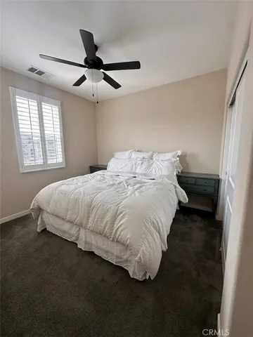 a large bed sitting in a bedroom next to a window and a chandelier