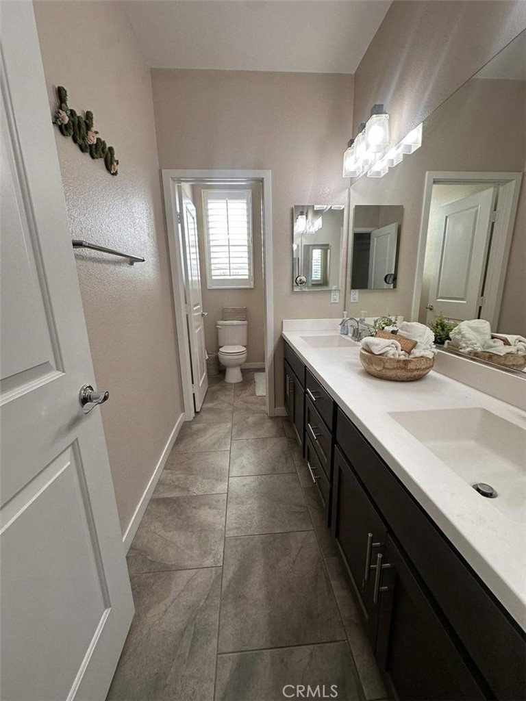 39552 Strada Scala Lake Elsinore, CA 92532 - Photo 26 of 40 a bathroom with a sink a vanity and a mirror